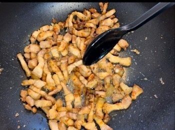 step3: 下半湯匙油落鑊，把五花腩炒至金黃色，加入冰糖繼續炒至上色。Put half a tablespoon of oil in the pan and brown the pork belly. Add rock sugar and continuing stirring to caramelise the pork.