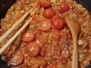 step5: 再加入適量的意粉醬和小蕃茄粒炒勻，調小火煮約8分鐘。