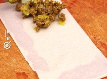 step6: 將卷皮一開二成兩個長方形，放入適量饀料
Cut each spring roll sheet into two rectangle. Add some filling.