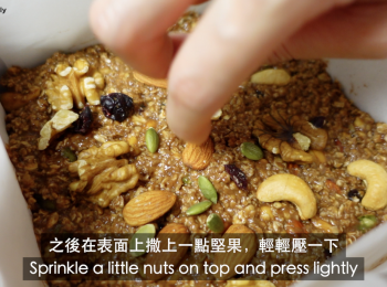 step5: 把混合好的燕麥糰倒入已鋪上牛油紙的烤盤中,之後在表面上撒上一點堅果，輕輕壓一下