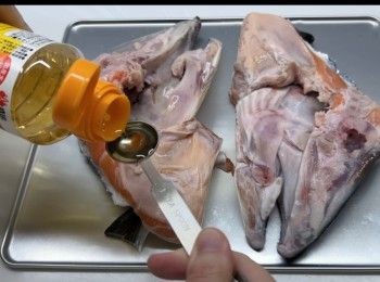 step4: 將三文魚頭用廚房紙完全吸乾水份之後，就可以進行調味。將味醂塗抹在整個三文魚頭上，再灑上鹽和黑椒。
醃製1小時。