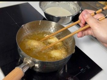 step5: 將油燒滾至150至155度（用中至細火），油滾後，就可以已沾炸漿的生蠔放入油炸。不要急着轉動生蠔，因為炸漿未硬，很容易會脫落。炸了40秒左右後，才開始慢慢轉動生蠔。