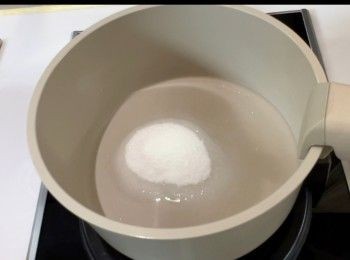 step4: 於煲內加入清水和砂糖，用細火將糖煮溶，並煮至滾起便離火。