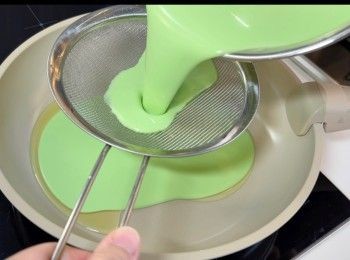 step7: 於不沾的平底鑊，加入1.5湯匙的油，再倒入已過篩的班蘭粉漿，然後用細火，將班蘭粉漿炒至凝固。