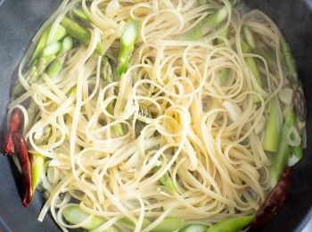 step4: 加入煮好的麵、蘆筍、鹽巴與1大杓的煮麵水拌炒至收乾。