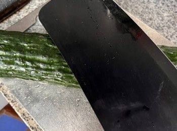 step3: 青瓜洗淨後切去頭尾，用打圈方式磨擦切面至出現白色泡沫，去除青瓜苦澀味。用刀略拍，拍扁後再用滾刀切塊。