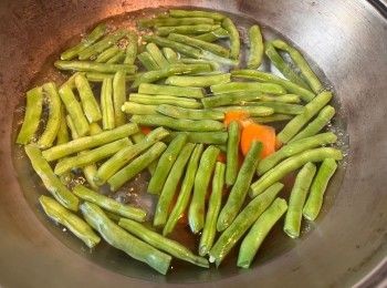 step3: 把四季豆去頭尾、撕去硬筋，切段。煮沸一鍋水，下少許鹽，把四季豆和甘筍片灼至九至熟。