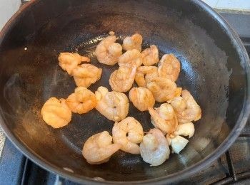 step4: 燒熱鍋、下少許油，下蝦仁和大蒜炒至蝦仁八成熟。