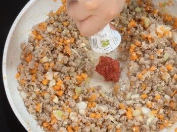 step11: 加入免治牛肉豬肉繼續炒香
加入一湯匙茄膏，繼續炒
炒至<span class="group_1">食材</span>變深紅色
加入一湯匙麵粉，輕輕炒勻