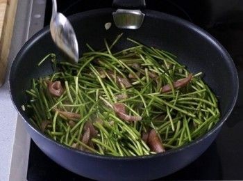step3: 燒熱油，爆蒜頭，加入香腸同炒。加入水蓮，下生抽調味，加入米酒拌勻。Heat the oil, stir fry garlic. Put in sausage and stir fry, then put in white water snowflake. Put in soy sauce and cooking rice wine, stir well.