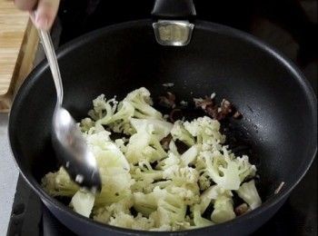 step2: 燒熱油，爆蒜頭和火腿拌炒，加入椰菜花拌炒。加入清湯和牛奶煮滾，加鹽 糖調味，蓋上煮2分鐘。粟粉水收汁。
Heat the oil, pan fry garlic and ham. Stir fry. Put in cauliflower. Put in chicken broth and milk to boil. Season with salt and sugar, Cover the lid and cook for 2 minutes. Thicken the sauce with cornst