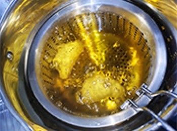 step15: 油燒至200℃，關火隔篩放上咸水角，慢慢放入。
當中要不停推動，使油旋轉滾動咸水角，色澤才會均勻