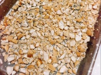 step3: 將20粒腰果（大概36 g左右；預留20粒作裝飾）打碎成粗粒，平均放在烤盤上，放中層，焗約6分鐘（150°；不需預熱）至金黃色（不同種類的堅果烤焗的溫度和時間都略有不同），然後打開焗爐門2-3吋（可用2個隔熱手套），用餘溫繼續焗至放涼，備用