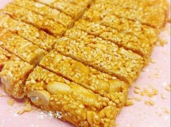 step14: 最後，拉起保鮮紙連同芝麻花生脆糖取出，切件（必需趁熱；不可以待放涼才切件，否則會容易碎裂），即成