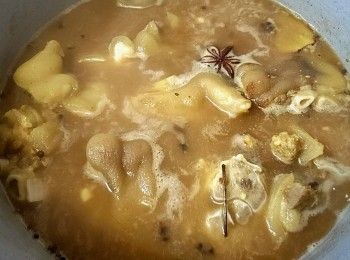 step13: 起油鑊爆香蒜頭 , 乾蔥 , 薑片放入花椒八角稍為兜炒至出香味 , 再放入豬手 , 贊入黃酒兜炒 , 加水至過面 , 放入冰糖 , 蠔油 , 五香粉 , 蟲花花粉 , 少許鹽大火滾起轉中細火滾 1'30 小時 , 熄火焗 30 分鐘 .