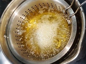 step16: 慢慢往下放入炸至起絲。
放下隔篩速度要慢皺，切忌快速皮會散掉。