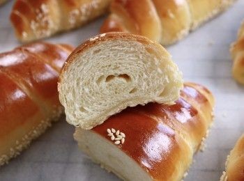 step2: 按壓麵團排氣，將麵團分成8等份，形成小圓形麵團。
鬆弛10分鐘，形成較長的麵團，鬆弛15分鐘。


將麵團擀平，形成一個45cm長的倒三角形。
在頂部放一塊牛油，輕輕捲起麵團
底部刷一層蛋液，底部黏上芝麻。
這個食譜總共可以製作8個奶油捲，您可以調整數量以形成較大/較小的麵包捲。