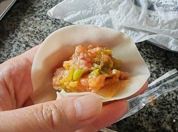 step4: 按皎皮的大少去放饀的比例多寡，對摺半圓留有少边捏實摺褶