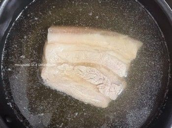 step2: 準備一鍋冷水，放入原條五花腩豬肉，倒入適量料理酒，中大火煮至滾起，然後轉細火慢煮20分鐘（不用上蓋）。
之後，準備一盤適用凍水，放入原條五花腩豬肉，浸3分鐘，冷凍肉質。