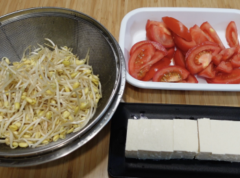 step1: 用水洗乾淨蕃茄，摘走蕃茄蒂，切片；用水洗乾淨大豆芽，挑走爛的大豆芽，有些人會摘走根位，看個人喜好，瀝水備用；用廚房紙巾抹乾硬豆腐表面，將硬豆腐切塊