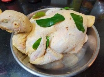 step8: 將醃汁塗抹雞身內外 , 再將檸檬葉 , 薑片放入雞身內外醃 45-60 分鐘 .