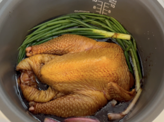 step3: 將雞放入電飯煲，雞背向下，蓋蓋按一般煮飯模式，煮10分鐘