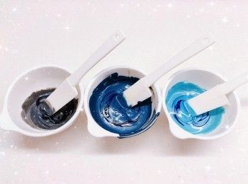 step6: <span class="group_2">朱古力脆皮外層</span>： 1. 將白朱古力用熱水坐溶（亦可用微波爐加熱1.5分鐘成朱古力醬；朱古力加熱不可超過50°，否則會變質而失去光澤） 2. 先將白朱古力溶液分成2部份（80 g＋170 g） 3. 再將白朱古力溶液（80 g）分成3份（10 g，加入適量的黑色食用色素，調成黑灰色＋40 g，用篩加入適量的竹炭粉和藍色食用色素，調成深藍色＋30 g，加入適量的藍色食用色素，調成藍色；如想呈現出大理石般的紋路，只需輕輕的切拌幾下即可，不需拌勻）