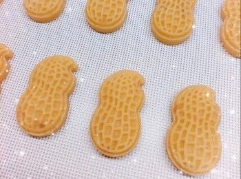 step5: 1. 將粉團分成一份份（約18-19 g），搓成橢圓形，放入月餅模（30 g；月餅模需均勻的塗上少許麵粉，再澄出多餘的麵粉）內壓花（每壓印一塊曲奇餅，月餅模都要塗上少許麵粉），然後將曲奇上多餘的麵粉輕輕掃走