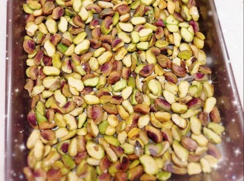 step3: 1. 再將開心果平均放在烤盤上，放中層，焗約6分鐘（150°；不需預熱）至金黃色（不同種類的堅果烤焗的溫度和時間都略有不同），然後用餘溫繼續焗，保溫備用（重點必須保持堅果溫暖；如買即食的堅果亦最好先以100°烤焗一會，讓其保持一定的溫度，否則加入棉花糖時會因降溫太快而令棉花糖定形）