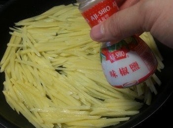 step2: 用平底鑊加油,將薯仔絲平均舖平於鑊中,不要攪動薯絲,薯絲自然會黏在一起,待薯絲煎至金黃,先在一邊潵上味椒鹽