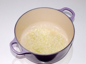 step3: 在另一個爐火上將高湯加熱保持一定的溫度(煮燉飯時需邊煮邊加高湯)。準備一個厚底鍋(鑄鐵鍋皆可),倒入橄欖油加熱,再放進洋蔥翻炒至透明狀