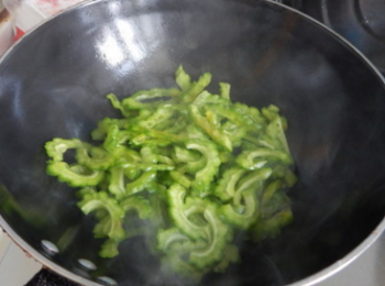 step6: 熱油，下苦瓜翻炒，接著下鹽翻炒。