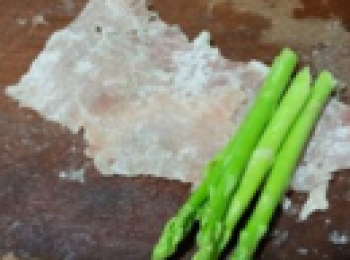 step3: 將錘成薄片的豬肉放糯米粉裡粘上薄粉，並拿四根或五根蘆筍在一側。