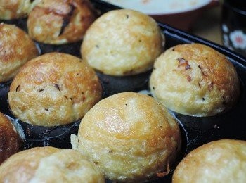 step9: 有香味傳出後，依序將丸子取出，然後再舀入麵糰，將丸子放上後，就成為圓型的丸子囉!!!如果油不夠可以再添入一點油，用竹籤將丸子翻動，讓每一個角落都煎到金黃色!!