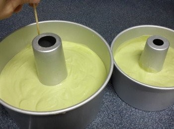 step16: 將蛋糕糊噔幾下，再由高处將蛋糕糊分別倒入8寸和6寸蛋糕模中， 用拇指輕按住柱狀內模， 其餘的手指則按住外模，拿起模型輕輕扣打， 讓麵糊均勻地平整開來再用竹籤插入麵糊內， 以畫圓的方式攪動，讓麵糊中多餘的氣泡釋出