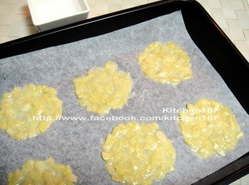 step7: 取一烤盤，鋪上烘焙紙，先用湯匙一小匙一小匙地勺進麵糊(約10元硬幣大)，兩兩間隔要寬。接著，就用手指頭將它推平推勻。(手指頭沾水，較好操作)(杏仁片不要有重疊，薄一點才會酥脆)