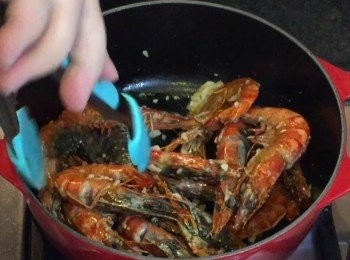step2: 用一個中型煲/鑄鐵煲，先落油用中火炒香一半分量的蒜蓉，再加入大蝦，贊酒炒至微熟，盛起備用。