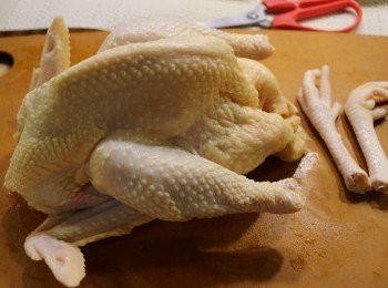 step2: 雞清洗乾淨，抹乾水分，斬去雞頭，切出雞爪。