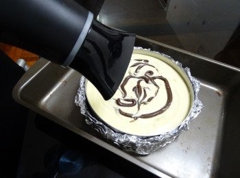 step8: 再將餘下的朱古力糊唧在蛋糕面， 用牙簽打圈劃成花紋（如畫花有困難可用風筒略吹便很容易）