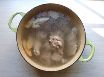 step2: 準備一個燉鍋加入適量的水,放入雞肉及薑片和蒜頭煮滾,過程中用湯勺將表面的浮末雜質撈除,蓋上鍋蓋轉小火燉煮25-30分鐘(燉煮時間可依個人喜歡雞肉的熟度做增減)。