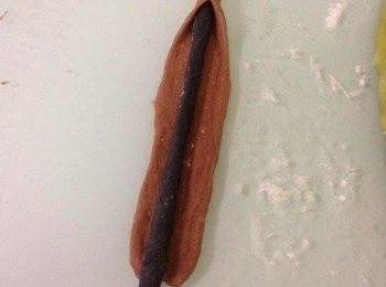 step6: 啡色麵團取其他的30g，分成 2 份, 推成2條大小相約的長條形, 然而壓平。將黑色的麵條將在啡色麵團上，然而用啡色麵團包著黑色麵團(如圖)。