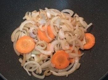 step3: 原鍋放入洋蔥用煎松阪豬的油炒香後，再放入紅蘿蔔片ㄧ起拌炒到洋蔥軟化。