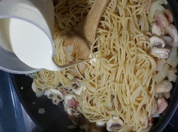 step12: 加入意粉炒勻,再落A汁料鮮奶100g,淡忌廉100g,轉用中火炒勻