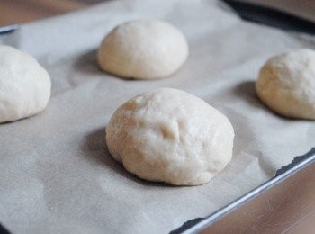 step7: 拿出麵團，用手按壓麵團，排出空氣，然後將麵團分成8至10分，搓圓。放在烘焙紙上，蓋好保鮮紙，靜置45分鐘作第二次發酵