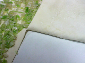 step8: 預留四分之一不舖蔥。由於蔥已經拌過油, 如面皮沾上, 收口時就不好收, 所以外圍預留收口的空間不舖蔥。