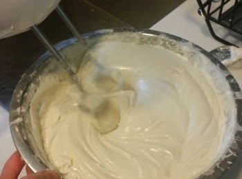 step4: 觀察糖溫~當糖溫到達126-130度間時,即可熄火將糖漿徐徐倒入打發的蛋白霜中.. 以邊倒入邊攪拌的方式..讓蛋白霜和糖漿充分融合均勻成牛軋糖~ 再接著加入120g牛油攪拌，倒入奶粉仔細拌均勻，最後加入200g蔓越莓攪勻~