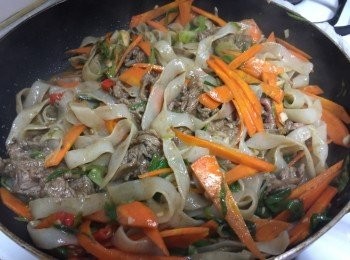 step6: 同一個鍋子，將蔥段、辣椒爆香後，放入蒟蒻河粉、紅蘿蔔、少許雞湯拌炒煮約6分鐘後，再加入1大匙醬油調味，最後加入炒過牛肉片以及青蒜拌炒，最後加入1大匙沙茶醬、1小匙米酒炒勻，起鍋時淋上香油即可起鍋囉。