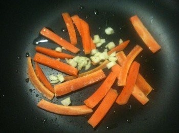 step2: 煉蒜油：平底鍋放入少許苦茶油（或是其他耐高溫的油品也可以）後，放入步驟1的切片紅蘿蔔和蒜末。