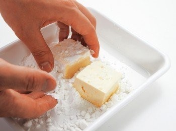 step3: 將豆腐切成8等分，拌上打散的蛋並裹上太白粉。