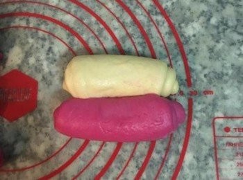 step11: 接著再次轉方向後,桿成長方形並捲起來； 而<span class="group_1">紅龍果麵糰</span>也是同樣壓、桿、捲的步驟。桿捲時，先拿一顆白的，再拿一顆紅的；並將ㄧ白ㄧ紅放在ㄧ起。依續完成8塊麵糰的桿捲。